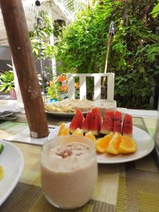 Mystic Maldives Mathiveri Retreat في ماثيفيري: صحن من الفاكهة ومشروب على طاولة