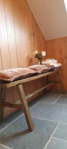 a wooden bench with a vase of flowers on it at De Blauwe Maaten in Neerglabbeek