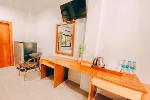 a bathroom with a wooden desk with a mirror and a chair at Chanpailin Omarzaa in Krabi town
