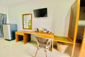 a desk with a mirror and a chair in a room at Chanpailin Omarzaa in Krabi town