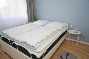 a large bed in a room with a window at Ferienwohnung mit neuer Küche u Bad - W-LAN in Damp