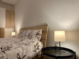 1 dormitorio con 1 cama y 1 mesa con 2 lámparas en Marienhaus Apartment - Zentral, Parken, Netflix, Kontaktloses Einchecken en Wuppertal