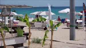 a beach with tables and chairs and the ocean at BOHO ROOMS MARTA in Priolo Gargallo