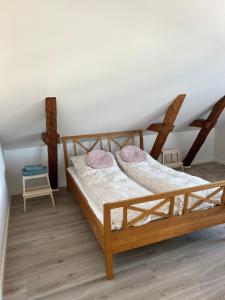 Hygge Loft في فاردي: غرفة نوم بسريرين خشبي مع وسائد وردية