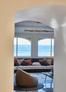 Pieds dans l'eau, villa de luxe 4 chambres في راماتويل: غرفة معيشة مع أريكة وبعض النوافذ