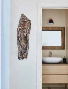 Pieds dans l'eau, villa de luxe 4 chambres في راماتويل: حمام مع حوض ومغسلة بيضاء