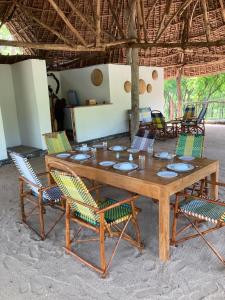 een houten tafel en stoelen en een tafel en stoelen bij Lemara Eco Camp in Kisaki