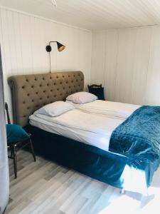 ein Bett mit einer blauen Decke und einer Lampe in einem Zimmer in der Unterkunft Lantlig Lägenhet in Charlottenberg