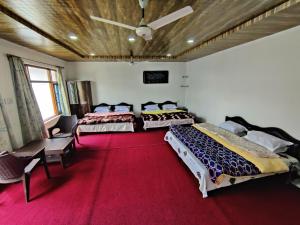 古爾默爾格的住宿－Kashmir Homestay，一间卧室配有两张床,铺有红地毯
