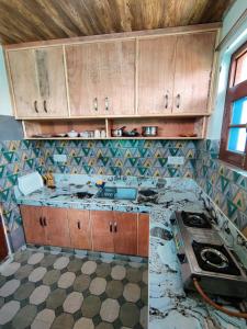 a kitchen with a damaged counter top and a stove at Kashmir Homestay in Gulmarg