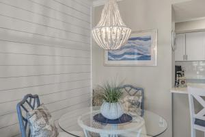 a chandelier hanging over a table and two chairs at Magnolia House 307 At Destin Pointe Resort in Destin