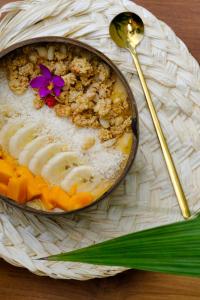 a bowl of food on a plate with a spoon at OASIA - Boutique Surf House (ADULTS ONLY) in Weligama