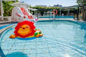 een speelgoedleeuw in het water bij een zwembad bij Peridis Family Resort in Kos-stad