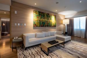 a living room with a white couch and a painting at Brittany Hotel BGC in Manila