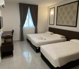 Habitación de hotel con 2 camas y ventana en Capital O 90756 Cara Hulu Hotel en Kampong Morten