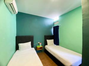 2 łóżka w pokoju z niebieskimi ścianami w obiekcie Sentosa Jaya Guest House near RS Hermina Medan RedPartner w mieście Medan