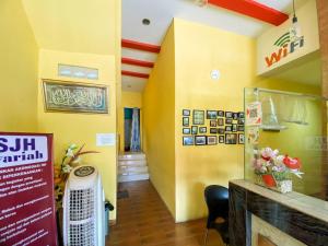 a restaurant with yellow walls and a flag on the wall at Sentosa Jaya Guest House near RS Hermina Medan RedPartner in Medan