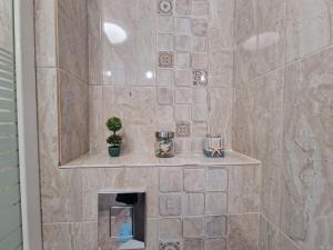 un bagno con doccia con parete in pietra di Laroka House Arty and Cosy studio Universitate Center a Bucarest