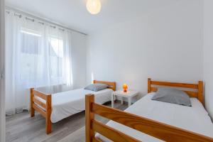 sypialnia z dwoma łóżkami i oknem w obiekcie Happy - Charmante maison de plain-pied w mieście Noyers-sur-Cher