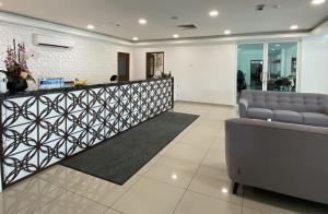 a lobby with a reception desk and a couch at Capital O 90756 Cara Hulu Hotel in Kampong Morten