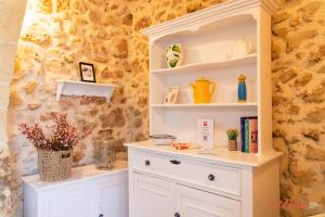 a room with a white hutch with flowers in it at Authentic Country Home with Incredible Outdoor Area in Xagħra