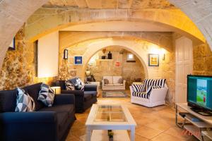 a living room with couches and a tv at Authentic Country Home with Incredible Outdoor Area in Xagħra