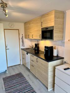 a kitchen with wooden cabinets and a black counter top at Holiday Apartment Köpingsvik in Köpingsvik