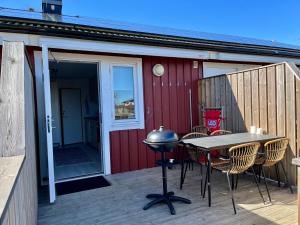 een patio met een tafel en stoelen en een grill bij Holiday Apartment Köpingsvik in Köpingsvik