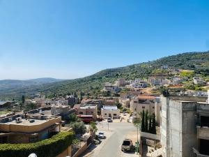 uitzicht op een stad met bergen op de achtergrond bij Your Home in Deir Ḥannā