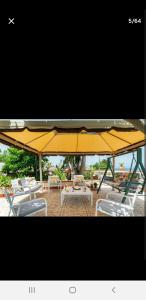 un ombrellone giallo e alcune sedie e un tavolo di Villa Teresa a Trappeto