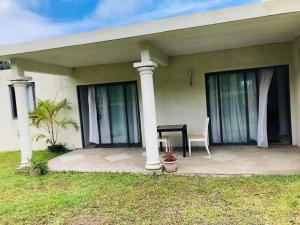 a house with a porch with a table and a chair at Le Kato Lux Rodrigues in Rodrigues Island