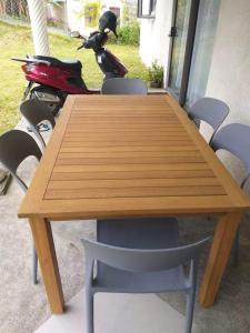 a wooden table and some chairs and a motorcycle at Le Kato Lux Rodrigues in Rodrigues Island