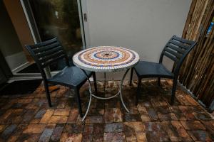 - une table et deux chaises sur la terrasse dans l'établissement The Wood Owl Nature's Valley, à Natureʼs Valley