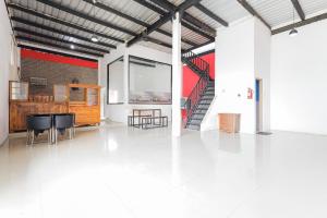 a large room with a white floor and a staircase at RedDoorz at Bypass Town Square Mojokerto in Mojokerto