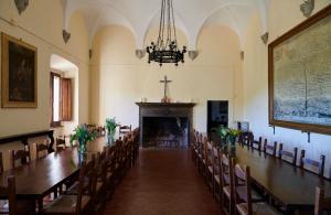 皮恩扎Monastero Sant'Anna in Camprena的教堂里带长桌子和椅子的房间