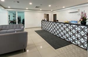 a lobby with a reception desk and a couch at Capital O 90756 Cara Hulu Hotel in Kampong Morten