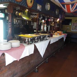 un buffet avec des assiettes de nourriture sur une table dans l'établissement Barons Galley & Lodge, à Hartswater