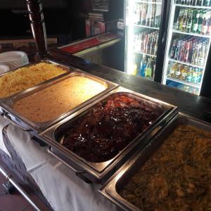 a buffet with three trays of food on a counter at Barons Galley & Lodge in Hartswater