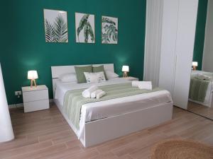 1 dormitorio con 1 cama grande y paredes verdes en TRISOLE Palermo en Palermo