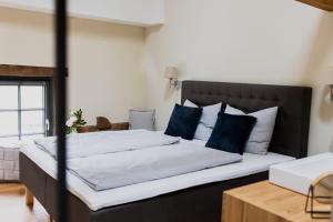 a bedroom with a large bed with blue pillows at Hofgut Schmitte in Gießen +94 photos
