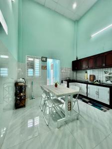 a large kitchen with a white table in it at Tứn' Home in Tây Ninh