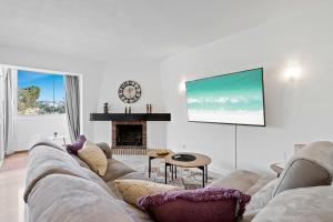 ein Wohnzimmer mit einem Sofa und einem TV in der Unterkunft Golf course view apartment Ref 198 in Fuengirola