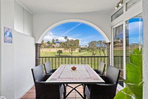 a dining room with a table and chairs on a balcony at Golf course view apartment Ref 198 in Fuengirola