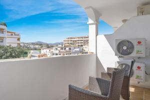 einen Balkon mit Stühlen und Stadtblick in der Unterkunft Golf course view apartment Ref 198 in Fuengirola