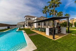 un patio trasero con piscina y una casa en Villa Burguillos, en Burguillos