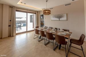 uma sala de jantar com uma grande mesa e cadeiras em Villa Burguillos em Burguillos