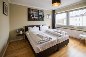 a bedroom with a bed with white sheets and a window at Luis City Apartments Regensburg in Regensburg