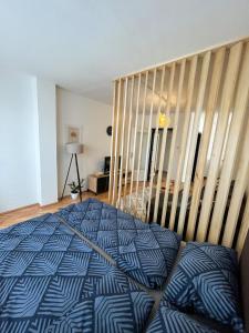 een slaapkamer met een blauw en wit bed en een trap bij Apartman MS in Bosanska Dubica