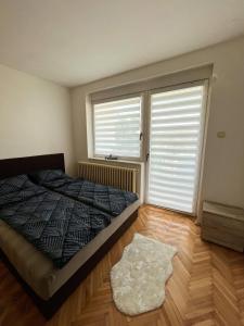 een slaapkamer met een bed en een groot raam bij Apartman MS in Bosanska Dubica