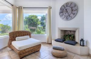 a living room with a chair and a clock on the wall at LongLands Peak at Windmill Hill in Albufeira +16 photos